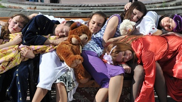 Junge Frauen schlafen auf einer Bank (gestellte Szene) | Bild: picture-alliance/dpa