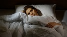 Person liegt wach im Bett. Warum ist Schlafmangel so schädlich? Wenn wir schlafen, erholt sich unser Körper und Geist. | Bild: colourbox.com