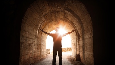 Mann schaut in die Sonne am Ende eines Tunnels. Freudlosigkeit, Antriebsmangel, Traurigkeit, Erschöpfung - das können Symptome einer Depression sein. Obwohl viele an der psychischen Erkrankung leiden, wird nur wenig darüber gesprochen. Hier findet ihr Infos und Anlaufstellen. | Bild: colourbox.com