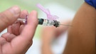 Ein Arzt impft eine Kollegin mit einem Grippeimpfstoff. | Bild: picture alliance/dpa | Felix Kästle