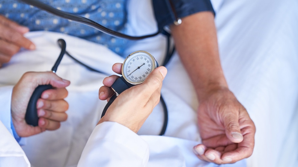 Ein Arzt misst bei einem männlichen Patienten den Blutdruck mit einem Messgerät. | Bild: picture-alliance/Zoonar|Robert Kneschke