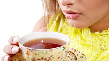 Bei einer Infektion mit dem Norovirus sollte man ausreichend trinken. Im Bild: Frauengesicht  mit einer Tasse Tee. | Bild: colourbox.com