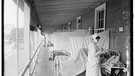 Eine Krankenschwester um 1918 zur Zeit der Spanischen Grippe versorgt Patienten, die während der Pandemie erkrankt sind.  | Bild: picture-alliance/dpa