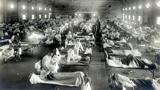 Patienten, die an der Spanischen Grippe (Influenza-Pandemie) erkrankt sind, liegen in einem Notfallkrankenhaus im Camp Funston der Militärbasis Fort Riley in Kansas, USA. | Bild: picture-alliance/dpa/National Museum of Health and Medicine