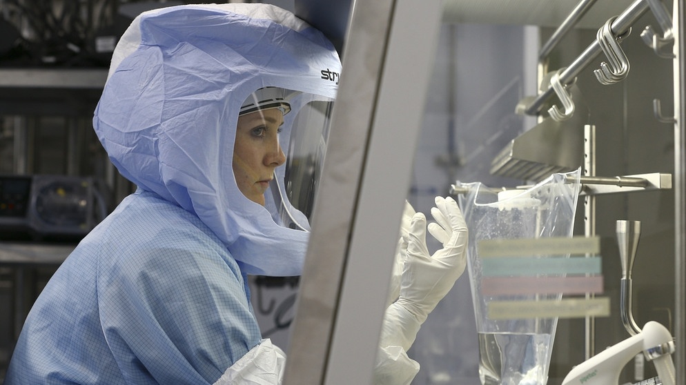 Angestellte der Firma Biontech in einem Schutzanzug bei der Überprüfung von mRNA-Impfstoffen. | Bild: picture-alliance/dpa/AA/Abdulhamid Hosbas