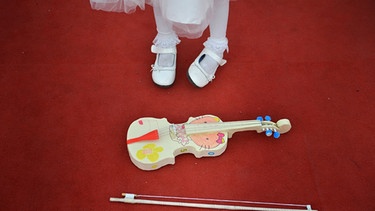 Eine chinesische Geigenschülerin mit ihrer aus Papier hergestellten Geige | Bild: picture-alliance/dpa