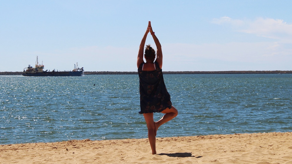 Eine Frau macht Yoga vor einer Strandkulisse. Braucht der Mensch wirklich einen Partner, um glücklich zu sein? | Bild: colourbox.com