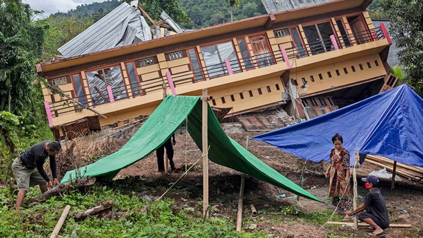 18.01.2021, Indonesien, Mamuju: Bewohner bauen Zelte vor ihrem Haus auf, das durch ein Erdbeben am 15.01.2020 schwer beschädigt wurde. Nach dem Erdbeben der Stärke 6,2 auf der indonesischen Insel Sulawesi ist die Zahl der Opfer um acht auf 81 gestiegen. Foto: Yusuf Wahil/AP/dpa +++ dpa-Bildfunk +++ | Bild: dpa-Bildfunk/Yusuf Wahil