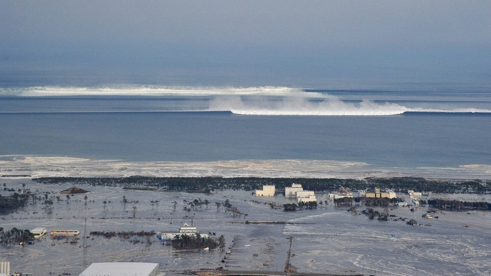 Die Tsunamiwelle rollt auf Natori in der Präfektur Miyagi im Nordosten Japans zu, nach dem schweren Erdbeben am 11. März 2011 | Bild: picture-alliance/dpa