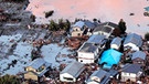 Tsunamiwelle bricht über die Präfektur Fukushima im Nordosten Japans herein nach dem schweren Erdbeben am 11. März 2011, die Häuser werden zerstört.  | Bild: picture alliance / dpa | Epa
