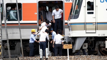 Passagiere steigen aus einem Zug, der nach dem Erdbeben im Juni 2018 in der Stadt Osaka automatisch gestoppt wurde.  | Bild: picture alliance/AP Photo | Yosuke Mizuno