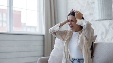 Eine Frau fasst sich an den Kopf. Viele Menschen leiden bei Föhn unter Wetterfühligkeit. Das der warme Wind Kopfschmerzen verursacht, ist allerdings nicht bewiesen. | Bild: colourbox.com