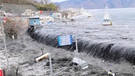Hier bricht bei der Mündung des Flusses Hei die Tsunamiwelle herein, nach dem schweren Erdbeben im Nordosten Japans am 11. März 2011. Starke seismische Aktivitäten und Verschiebungen tektonischer Platten können riesige Flutwellen, japanisch: Tsunamis auslösen. | Bild: picture-alliance/dpa