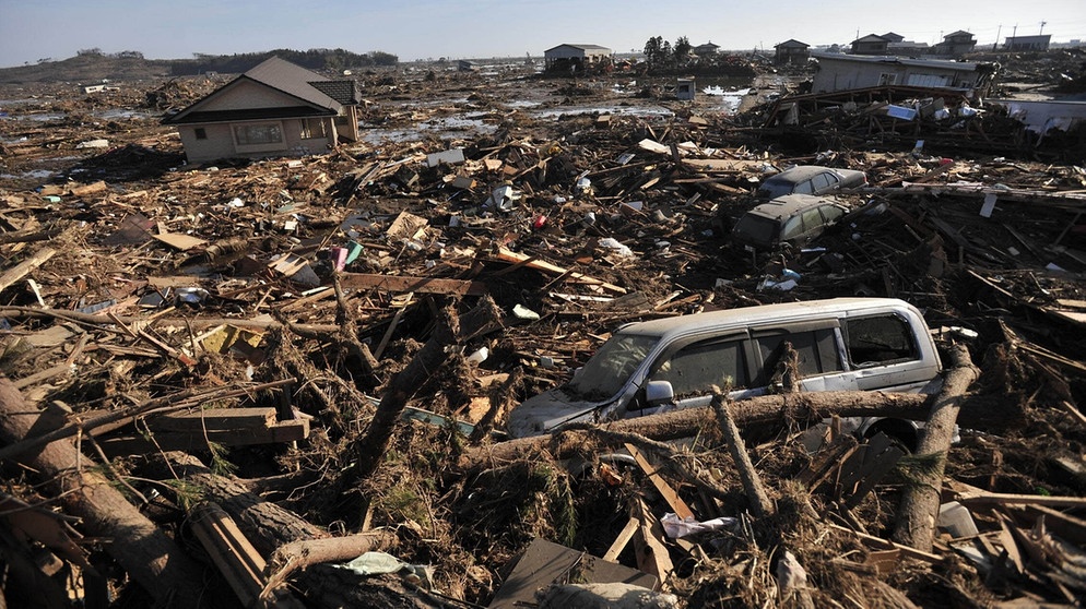 Schwere Schäden in der Provinz Fukushima im Nordosten Japans nach dem schweren Erdbeben und Tsunami vom 11. März 2011. Starke seismische Aktivitäten und Verschiebungen tektonischer Platten können riesige Flutwellen, japanisch: Tsunamis auslösen. | Bild: picture-alliance/dpa