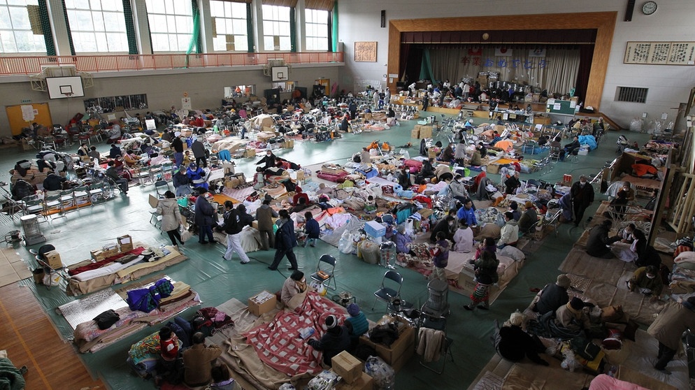 Obdachlose Überlebende in einer Notunterkunft in Minami Senriku im Nordosten Japans nach dem schweren Erdbeben und Tsunami vom 11. März 2011, die auch die Nuklearkatastrophe von Fukushima nach sich zogen. | Bild: picture-alliance/dpa
