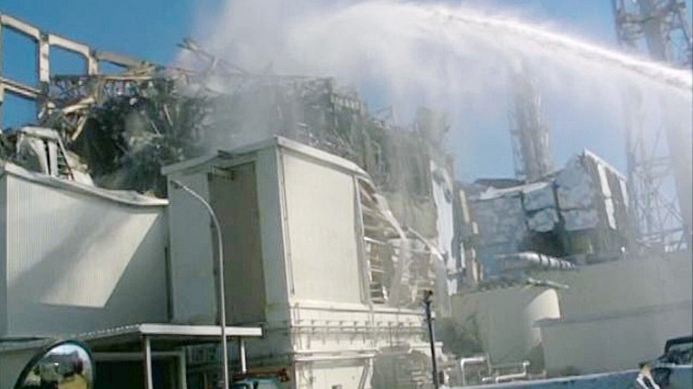 Löschzüge versuchen den Brand im Atomkraftwerk Fukushima zu löschen. Am 10. März 2011 zerstörte erst ein Erdbeben und der darauffolgende Tsunami das Kernkraftwerk im Norden Japans.  | Bild: picture alliance  dpa  Kyodo