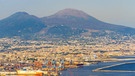 Die Stadt Neapel, im Hintergrund ist der Vulkan Vesuv zu sehen. Vulkane findet man auf der ganzen Welt - sogar hier in der Eifel und in Bayern. Die Feuerberge sind Lebensspender, Rohstofflieferant, Touristenmagnet, aber auch Zerstörer und Todbringer. Wir erklären, wie Vulkane entstehen, Lava spucken, uns nützen und schaden. | Bild: picture alliance/Bildagentur-online/AGF-Valetta