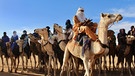 Tuaregs auf Kamelen im Niger. Bezieht man Halbwüsten mit ein, gehören den Wüsten mit rund 50 Millionen Quadratkilometern von allen Landschaftsformen der Erde die größte Fläche. Ein faszinierender und Lebensraum für eine besondere Tier-und Pflanzenwelt. Hier erfahrt ihr mehr über die trockensten Gebiete der Welt. | Bild: picture alliance/AP Photo | Ludivine Laniepce