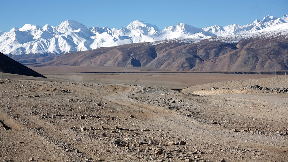 Schotterpiste in der tibetischen Wüste. Die Regenschattenwüsten der Erde werden von Gebirgen abgeschirmt, deren Berge wie eine Barriere gegen Regen wirken. Hier erfahrt ihr mehr über diese besonderen Wüsten.  | Bild: picture-alliance/dpa