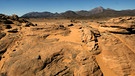 Steinwüste Dschebel Uweinat in der sudanischen Sahara. Die Landschaften der Wüste der Erde sind weltweit unterschiedlich. Milliarden von Sandkörnern, Dünen, Schotterebenen, Felsgebirge, Salzseen und auch Eisflächen prägen die trockensten Gebiete der Welt. | Bild: picture-alliance/dpa