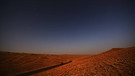 Eine Straße führt durch die Binnenwüste Taklamakan in Xinjiang, China. Der Sternenhimmel ist zu sehen. Wüsten sind ein faszinierender Lebensraum für eine besondere Tier- und Pflanzenwelt. Hier erfahrt ihr mehr über die trockensten Gebiete der Erde. | Bild: picture alliance/QUEHURE/Costfoto