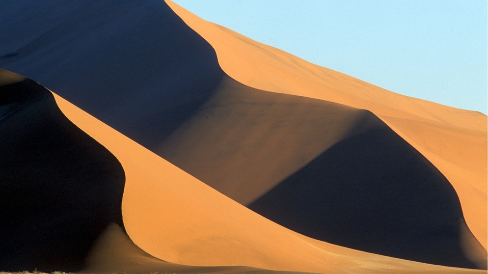 Sossusvlei-Dünen in der Namib-Wüste, eine Wüste direkt am Meer. Küstenwüsten befinden sich in der Nähe von kalten Ozeanströmungen aus der Antarktis. Kühle Luft kann wegen warmer Passatwinde nicht aufsteigen, Wolken und Regen bleiben aus. | Bild: picture-alliance/dpa