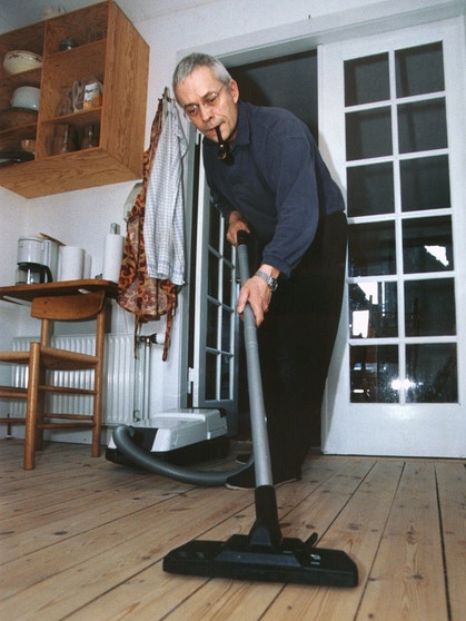 Mann saugt einen Dielenboden mit Staubsauger. | Bild: dpa - Bildarchiv