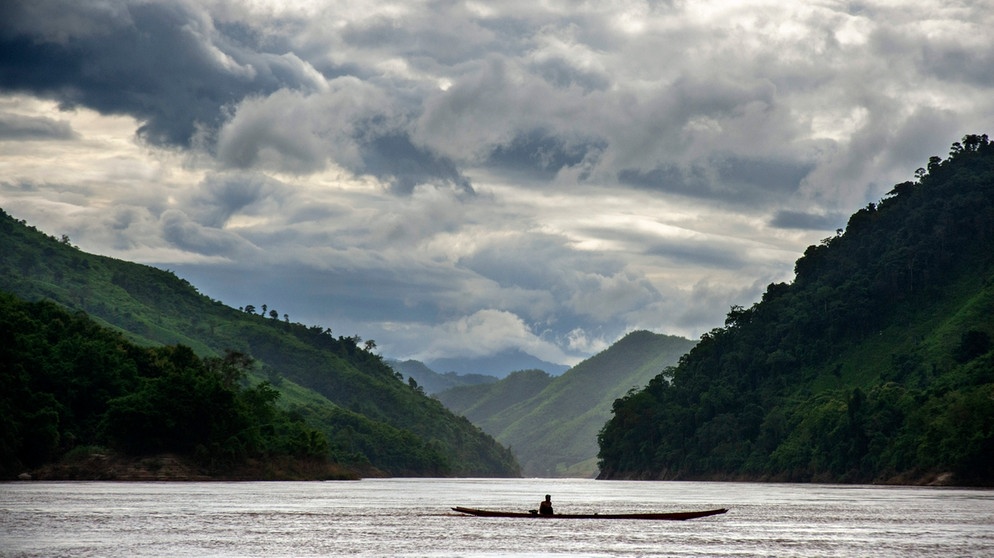 Ein Fischer überquert in seinem Boot den Fluß Mekong von Thailand nach Laos.  | Bild: picture alliance / Sergi Reboredo