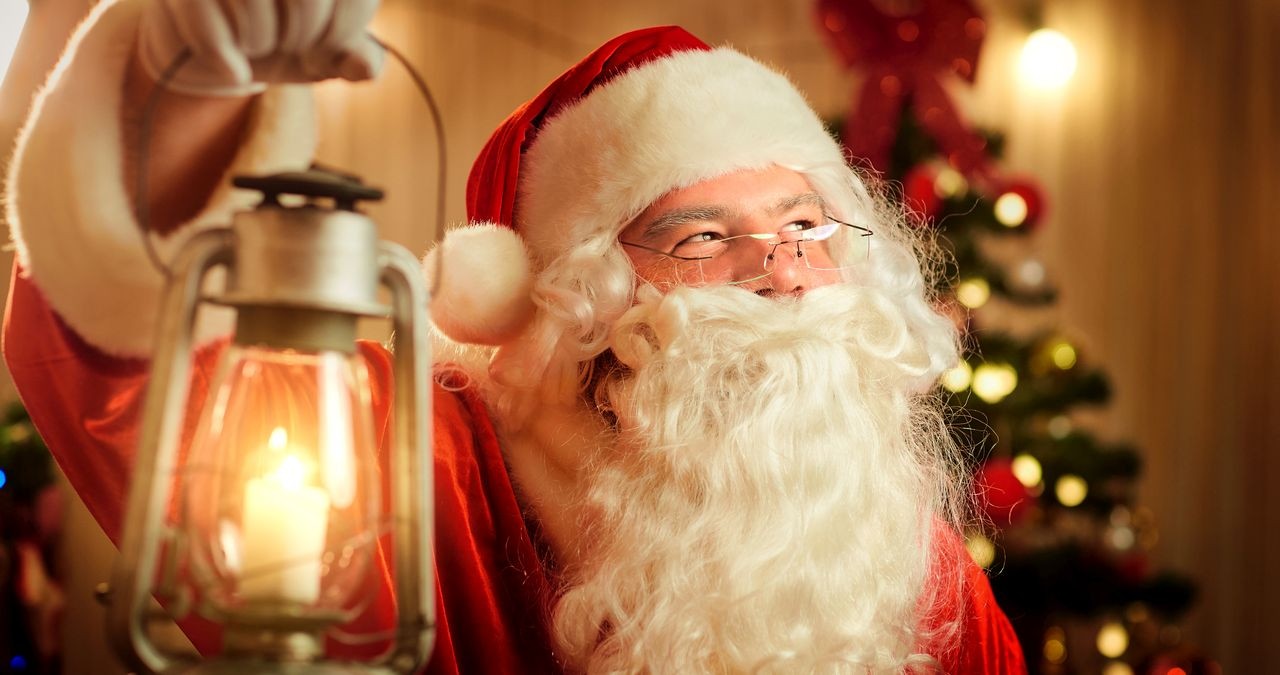 Nikolaus vor einem Christbaum hält eine Lampe in der Hand. | Bild: colourbox.com