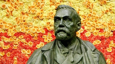 Eine Statue von Alfred Nobel bei der Verleihung des Nobelpreises in der Stockholmer Konzerthalle.  | Bild: picture alliance / Photoshot