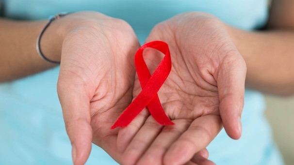 Die rote Schleife steht als Symbol für die Immunschwächekrankheit AIDS. | Bild: picture alliance/Andriy Popov