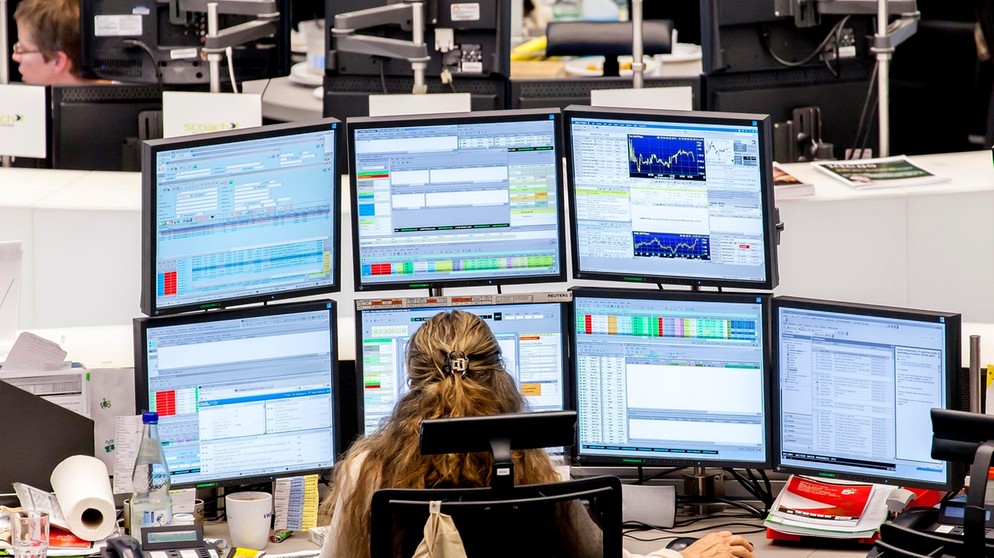 Eine Börsenmaklerin sitzt vor fünf Bildschirmen und behält die Kurse im Auge. | Bild: picture alliance / imageBROKER | Stefan Kiefer