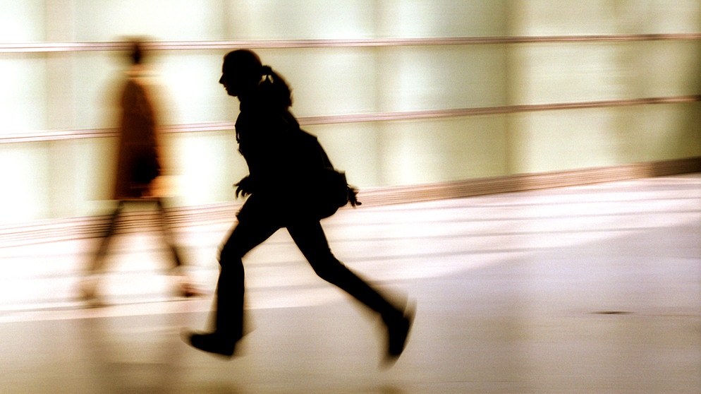 Die Silhouette einer rennenden, jungen Frau. Viele Menschen treibt die Angst um, in ihrer Freizeit etwas zu verpassen. Wir haben Tipps gegen FOMO und Freizeitstress, damit ihr euch in eurer freien Zeit wirklich erholt. | Bild: picture alliance / Caro | Hechtenberg