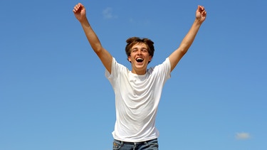 Ein Mann freut sich und streckt die Arme zum Himmel aus. Was ist Glück? Wann fühlt man es und wie? Und kann man dem Glücksgefühl auch auf die Sprünge helfen? Wir haben für euch Infos und Tipps zum Glücklichsein gesammelt. | Bild: colourbox.com