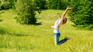 Junge Frau springt glücklich auf einer Wiese in die Luft. Was ist Glück? Wann fühlt man es und wie? Und kann man dem Glücksgefühl auch auf die Sprünge helfen? Wir haben für euch Infos und Tipps zum Glücklichsein gesammelt. | Bild: colourbox.com