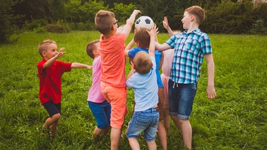 Eine Gruppe Kinder spielt Ball in einem Garten. Die Fähigkeit zur Empathie entwickelt sich bei Kindern über die Jahre. Eltern können diese Entwicklung unterstützen, etwa in dem sie ihren Kindern beibringen, über Gefühle und Bedürfnisse zu sprechen.   | Bild: colourbox.com