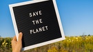 "Save the Planet" Schild vor einem Feld. Weil immer mehr Menschen Klimaangst und Sorgen vor ihrer Zukufnt, den Folgen des Klimawandels haben, werden sie aktiv. | Bild: picture alliance/Zoonar | Anastasiia Yanishevska