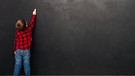 Junge schreibt an leerer großer Tafel. Kinder mit Legasthenie haben Probleme beim Lesen und Schreiben. Wie schaffen sie trotz Legasthenie das Gymnasium? Und was können die Ursachen für eine Lese- und Rechtschreibschwäche sein? Das und mehr erfahrt ihr hier. | Bild: colourbox.com