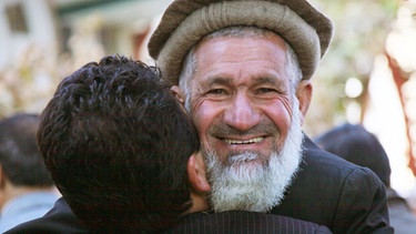 Männer umarmen sich in Afghanistan. Die berühmtesten Filmküsse, Kuss-Traditionen in anderen Ländern und Reaktionen des Körpers während des Knutschens - hier erfahrt ihr alles Wichtige rund um den Kuss. | Bild: picture-alliance/dpa