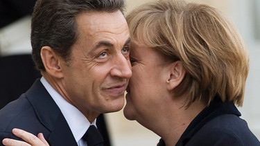 Angela Merkel küsst Nicolas Sarkozy auf die Wange. Die berühmtesten Filmküsse, Kuss-Traditionen in anderen Ländern und Reaktionen des Körpers während des Knutschens - hier erfahrt ihr alles Wichtige rund um den Kuss. | Bild: picture-alliance/dpa