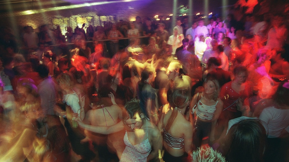 Verschwitzte Menschenmassen tanzen zu wummernder House-Musik.  | Bild: picture-alliance/dpa