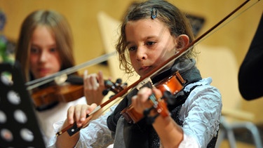 Schülerinnen musizieren auf Violinen. | Bild: picture-alliance/dpa