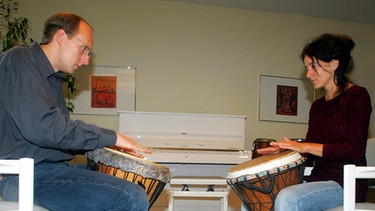 Musiktherapeut trommelt zusammen mit Patientin in Klinik für Tumorbiologie in Freiburg. | Bild: picture-alliance/dpa