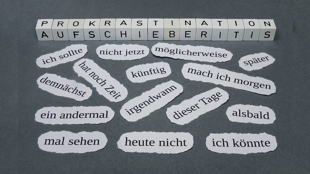 Prokrastinieren ist weit verbreitet. Im Bild: Zeitungsschnipsel mit Wörtern, die das Aufschieben bveschreiben. | Bild: Imago Steinach, SR
