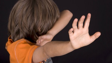Junge wehrt sich und hält sich die Arme schützend vor das Gesicht  | Bild: picture-alliance/dpa/blickwinkel