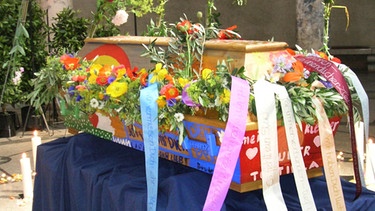 Bunt bemalter, mit Blumen und Bändern dekorierter Sarg.  | Bild: picture-alliance/dpa