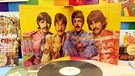 Beatles-Coverbox, im Vordergrund eine Single-Schallplatte | Bild: picture-alliance/dpa