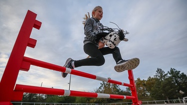 Johanna springt auf ihrem Steckenpferd Flecki über ein Hindernis.   | Bild: dpa-Bildfunk/Jan Woitas