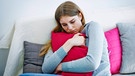 Junge Frau hält ihr Kissen fest im Arm | Bild: picture alliance / Zoonar | ulrike schanz
