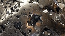 Zu einer Kugel geformtes Pyrit. Dieses Mineral ist auch als Eisenkies, Katzen- oder Narrengold bekannt. Die Bezeichnung Pyrit leitet sich vom altgriechischen Wort "pyr" ab, auf Deutsch "Feuer". | Bild: picture-alliance/dpa